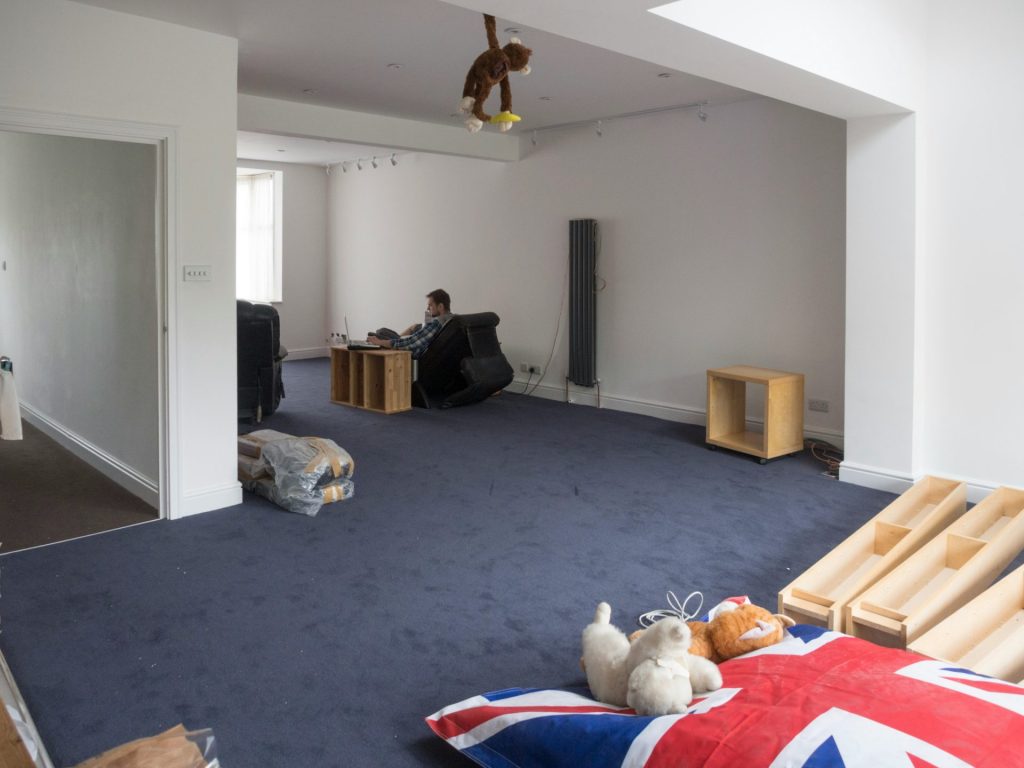 Empty room with blue carpet and various items.